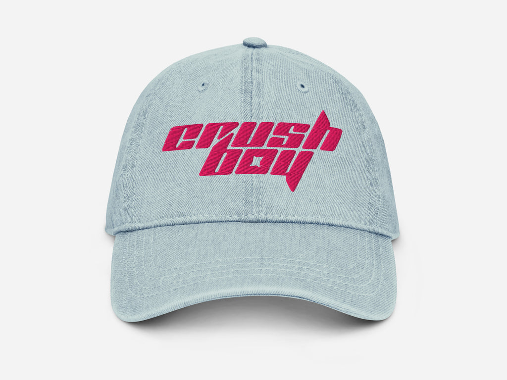 A light blue denim baseball cap featuring a bold pink embroidered 'CRUSHBOY' logo on the front, set against a clean white background.
